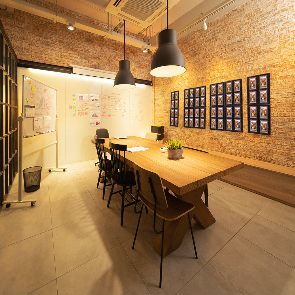 An office space showcasing a wall display of 48 PSA slabbed trading cards.